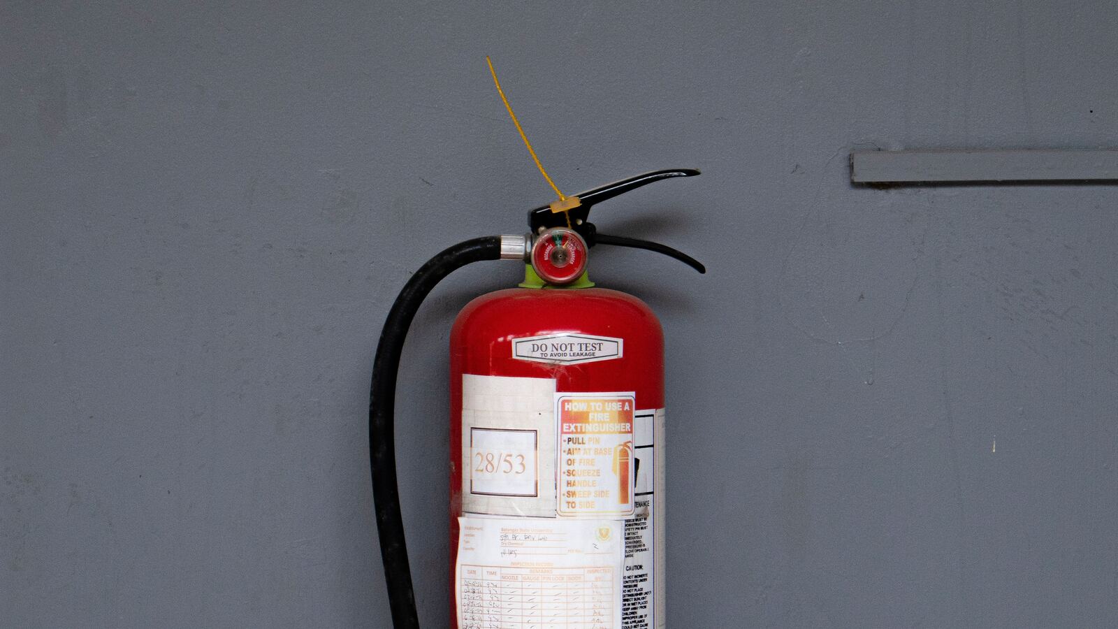 Extintor contra incendios instalado en pared, parte del programa de Protección Civil gestionado por Allstar