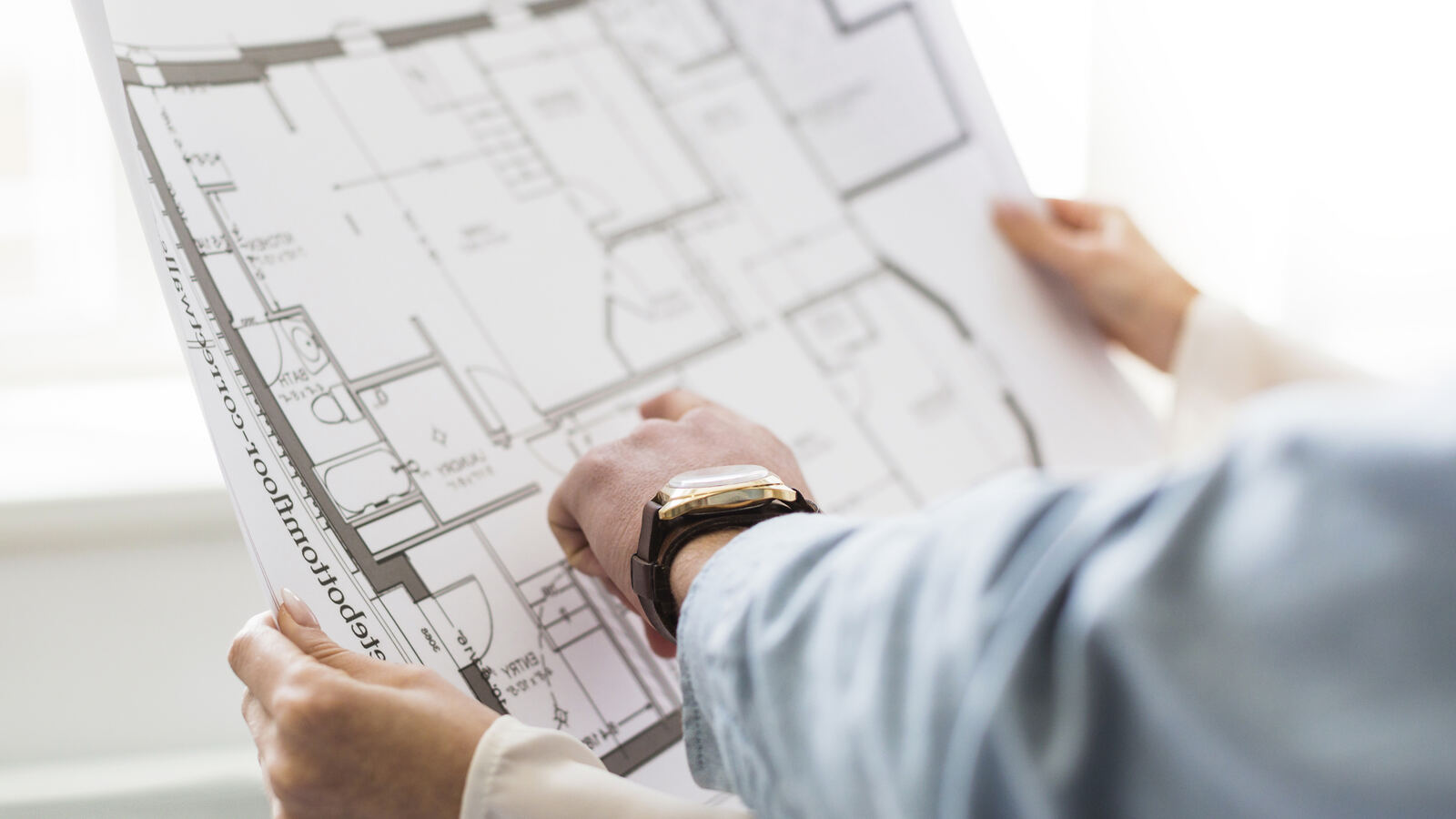 Especialista revisando planos arquitectónicos y normativos para los servicios de cumplimiento de Allstar