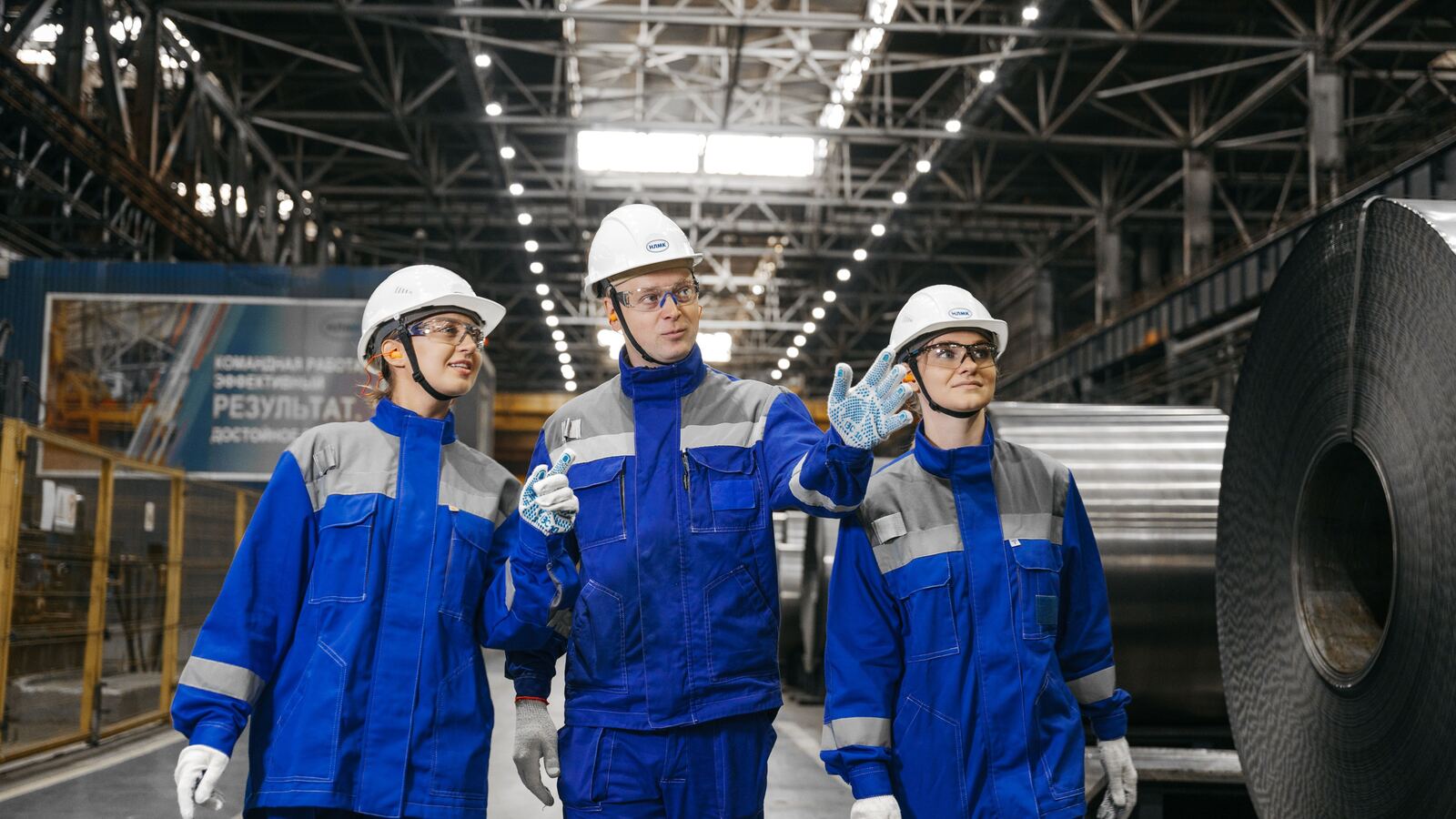Trabajadores con equipo de protección personal caminando en planta industrial cumpliendo normas STPS